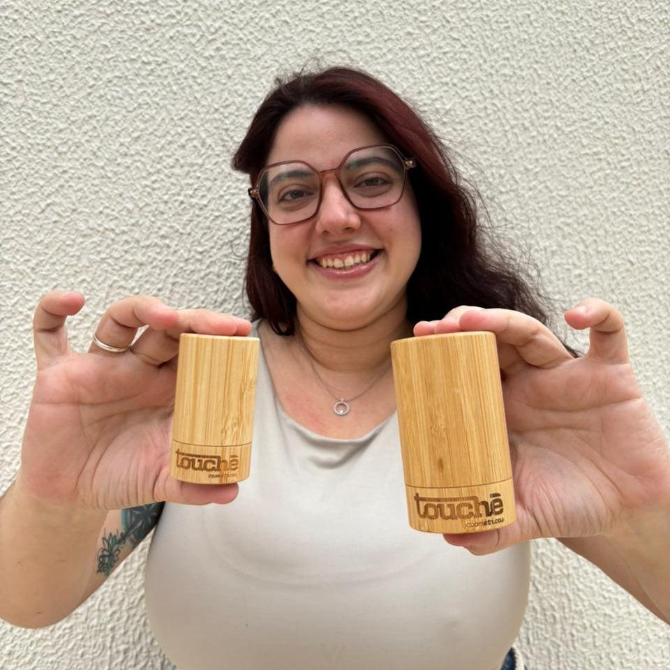 Mulher segurando dois desodorantes de cristal naturais