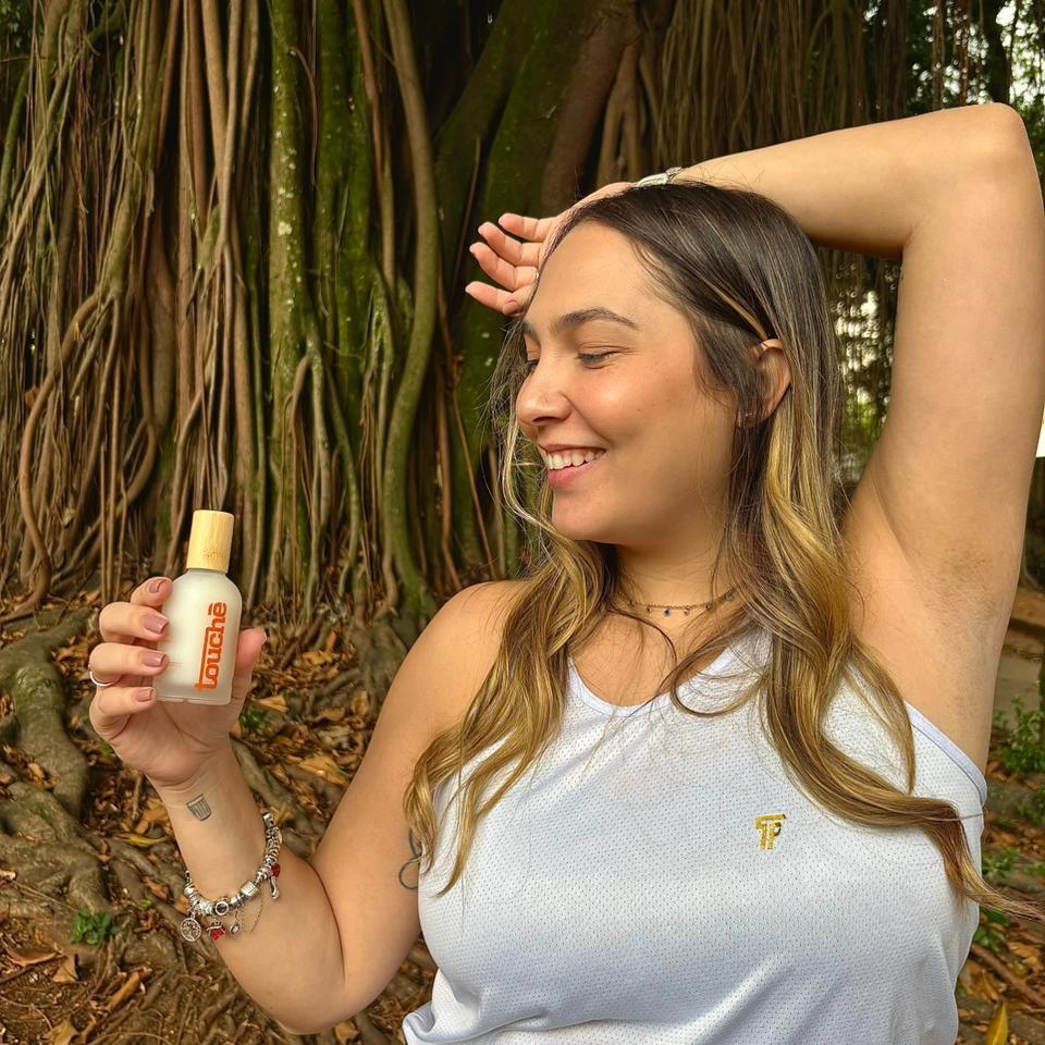 Mulher sorrindo com desodorante natural sem toxinas, ao ar livre, proteção o dia todo